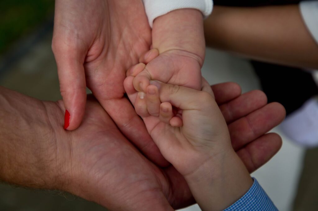 Close-up of a family joining hands, symbolizing love and connection.